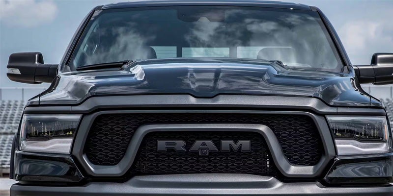 Front view of a dark gray Ram pickup truck with black grille and prominent RAM lettering.