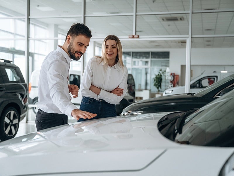 Customers with a salesperson in the dealership showroom