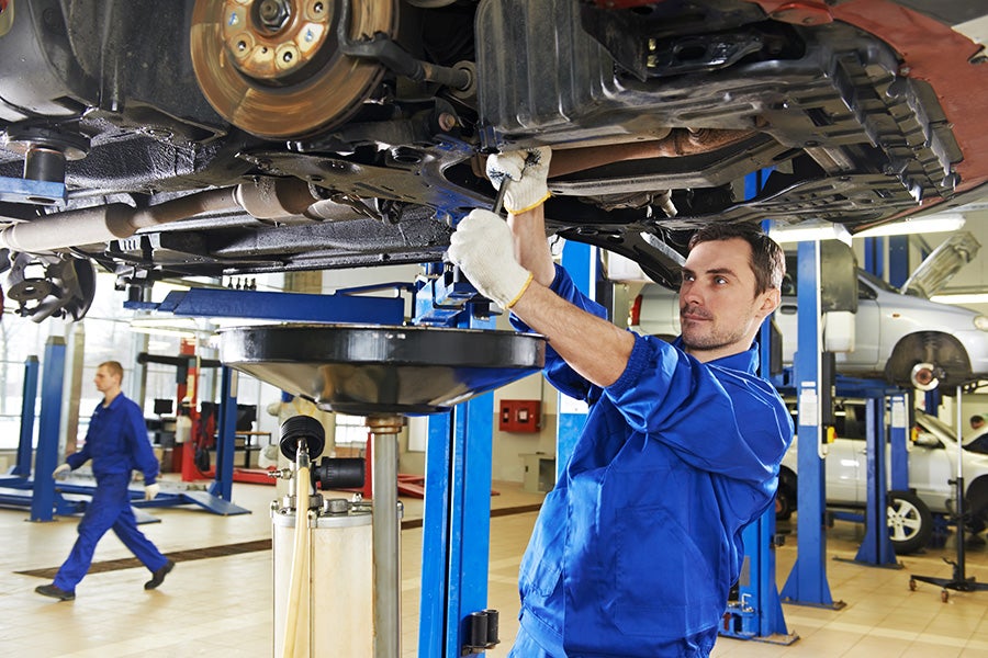 service technician working on a vehicle in the service bay