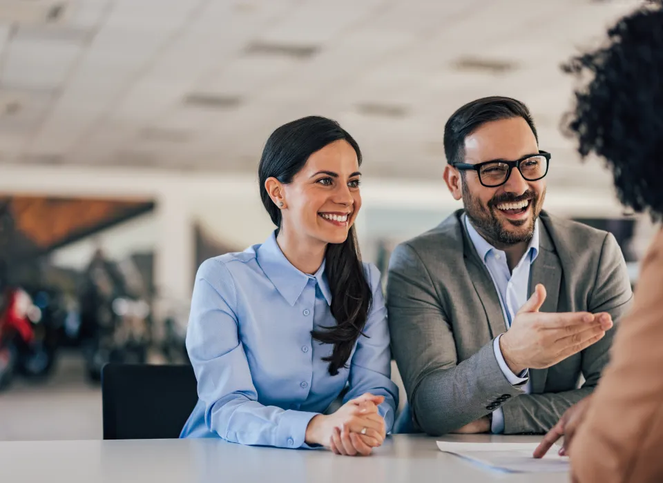 Dealership employee pointing to finance paperwork